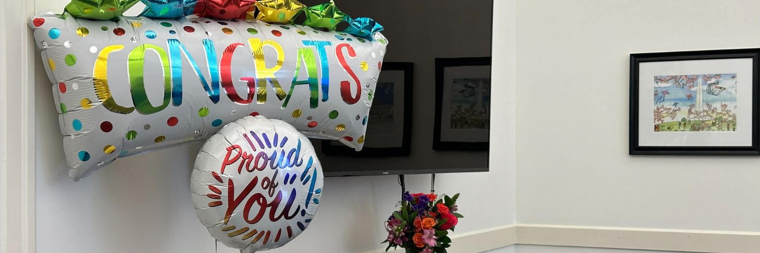 Mylar balloons that say "Congrats" and "Proud of You"