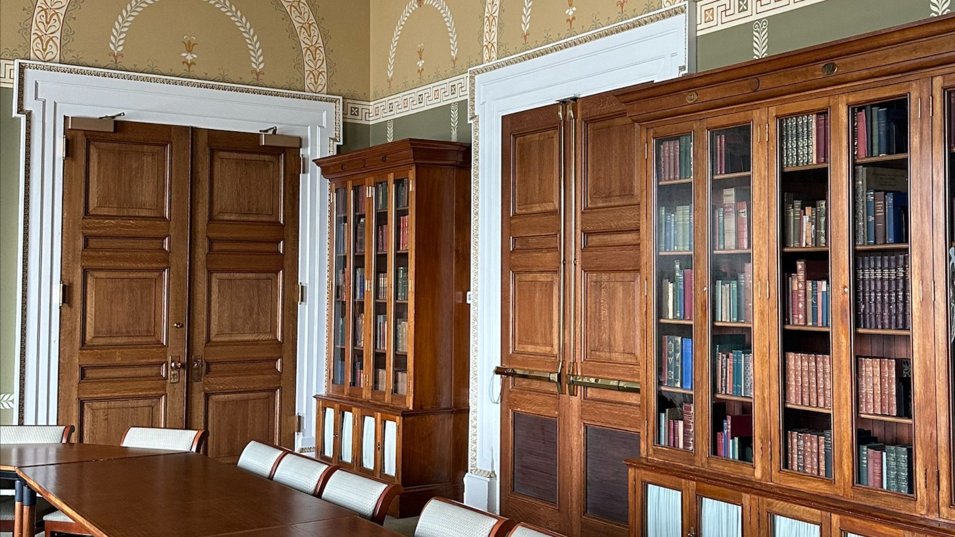 Room with chairs around conference tables and bookshelves lining the back wall