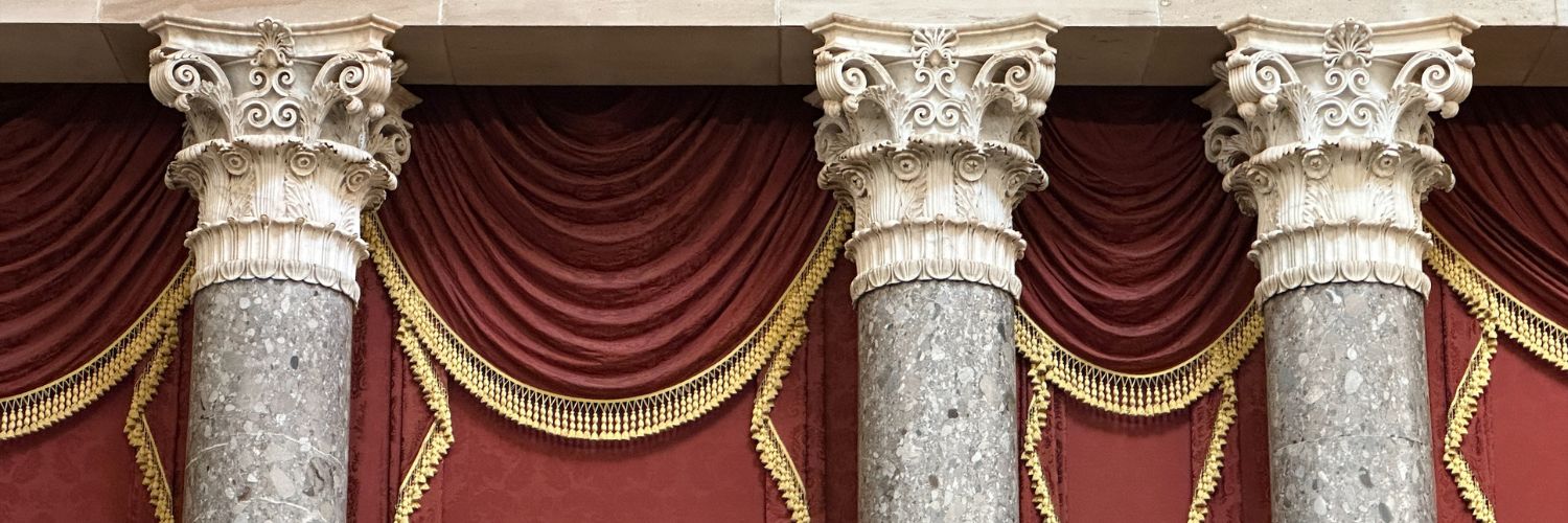 Corinthian columns with red curtains draped in between